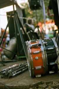 Drum set and music equipment at an outdoor concert, showcasing a vibrant atmosphere.